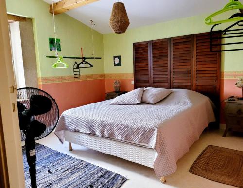 une chambre avec un lit et une tête de lit en bois dans l'établissement LES CHAISES LONGUES, à Peyrins