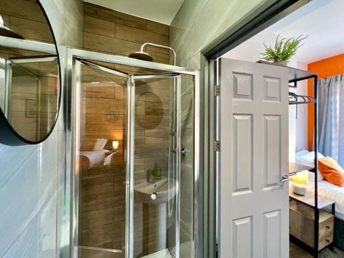 a bathroom with a shower and a glass door at Birkin House - Urban Oasis Townhouse in Nottingham