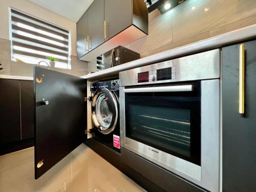 a kitchen with a microwave and a washer and dryer at Birkin House - Great for Contractors or Family Holidays in Nottingham