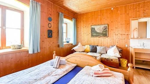 1 dormitorio con 2 camas en una pared de madera en Almbauernhof en Ruhpolding