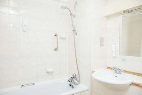 biała łazienka z prysznicem i umywalką w obiekcie Fieldhead Hotel by Greene King Inns w mieście Markfield