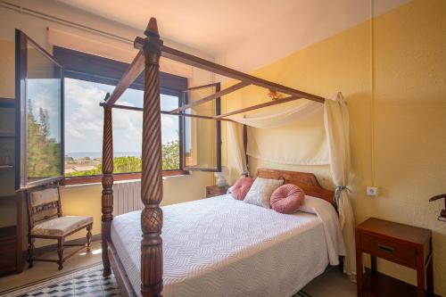 a bedroom with a canopy bed and a window at Habitaciones Villa Marcia Solo Adulto in Altafulla