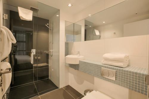 a bathroom with a toilet and a sink and a mirror at Terrace Apartments - Stay Here Queenstown in Queenstown