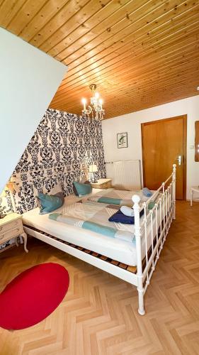 a large white bed in a room with a wooden ceiling at Almbauernhof in Ruhpolding