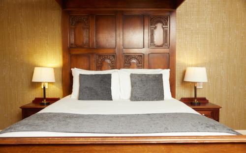 a bedroom with a large bed with two lamps at Fieldhead Hotel by Greene King Inns in Markfield