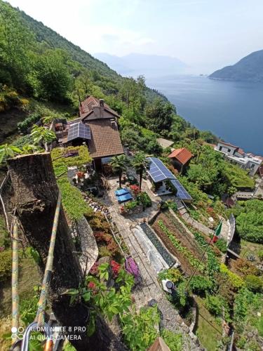 an aerial view of a house on a hill next to the water at Wellness Suite Apartment - Whirlpool-Sauna-Private Pool -Lake View in Maccagno Superiore