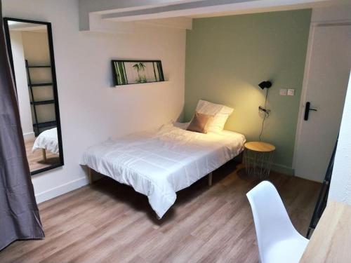 Schlafzimmer mit einem weißen Bett und einem Spiegel in der Unterkunft Zenitude Place in Margny-lès-Compiègne