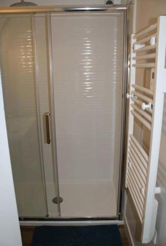 a shower with a glass door in a bathroom at Zenitude Place in Margny-lès-Compiègne