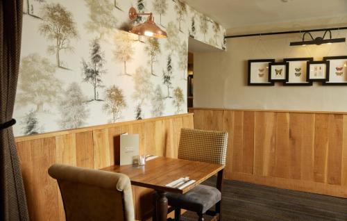 a dining room with a wooden table and chairs at Fieldhead Hotel by Greene King Inns in Markfield