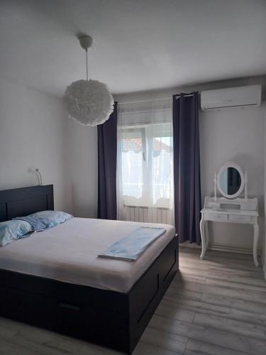 a bedroom with a large bed and a window at Apartmani Rameša in Murter