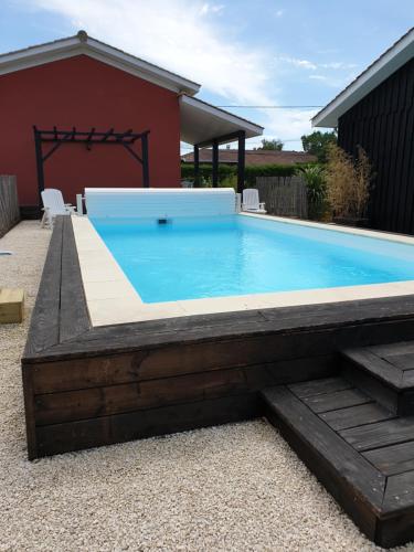 una piscina con terrazza in legno e un piscina con idromassaggio di maison avec piscine a Le Porge