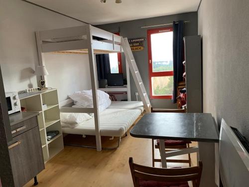 - une chambre avec des lits superposés, une table et un bureau dans l'établissement Agréable Studio 3 Places à P2000 Résidence Les Myrtilles, à Bolquère-Pyrénées 2000