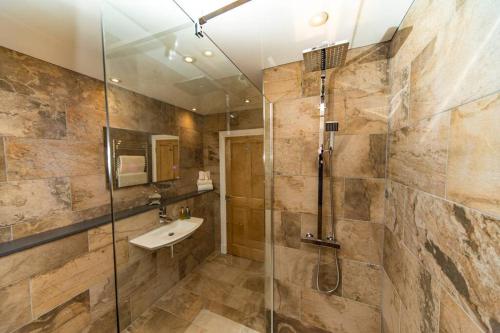 a bathroom with a sink and a glass shower at Avernish Lodge-Luxury Self Catering in Kirkton