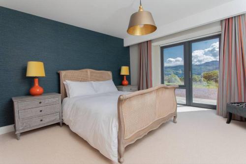 a bedroom with a bed and a large window at Avernish Lodge-Luxury Self Catering in Kirkton