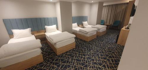 una camera d'albergo con due letti e un divano di Al-Manahel Royal Hotel a Najaf