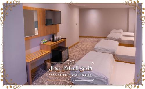 Habitación con 2 camas y TV de pantalla plana. en Al-Manahel Royal Hotel en Nayaf
