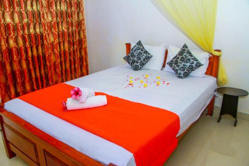 a bedroom with a bed with confetti on it at Sigiri Nirwana Lodge in Sigiriya