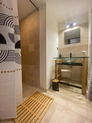 ein Badezimmer mit einem Glaswaschbecken und einem Spiegel in der Unterkunft mas du Belbuis in Rochegude