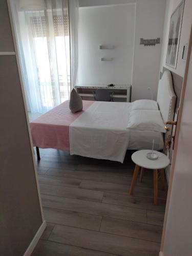 a small bedroom with a bed and a table at Le Sculture B&B in Cosenza