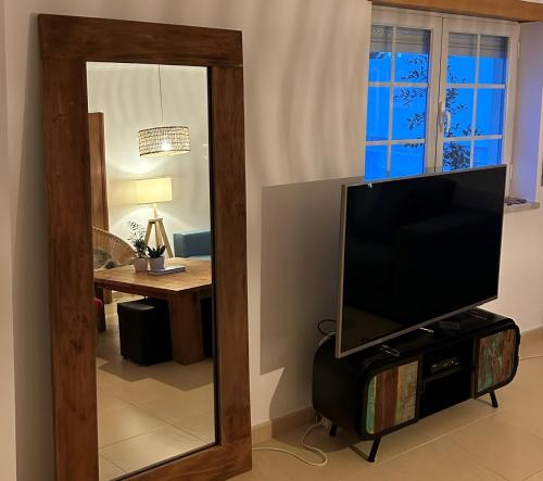 een televisie die op een standaard voor een spiegel staat bij Wave - Beach House, Baleal in Baleal