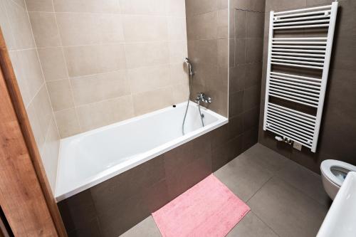 Bučovice的住宿－GLAM apartmán Bučovice，带浴缸和卫生间的浴室。