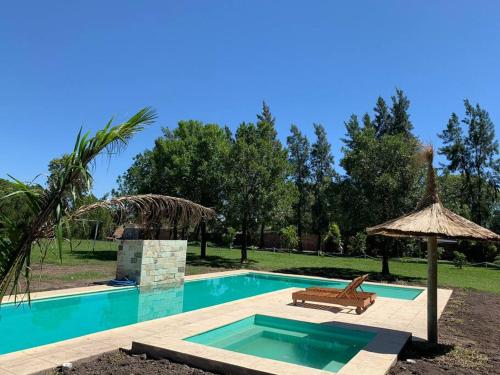 a swimming pool with a chair and an umbrella at Quinta Las Flores in Reconquista