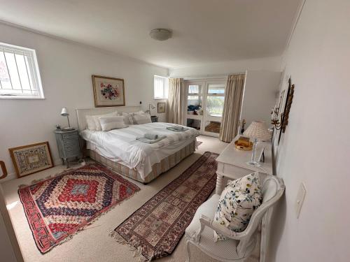 1 dormitorio con 1 cama, 1 mesa y 1 silla en Spectacular views Simonstown en Ciudad del Cabo