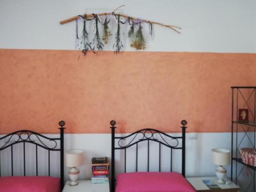 a bedroom with two beds and an orange wall at Insula -- Telti in Telti