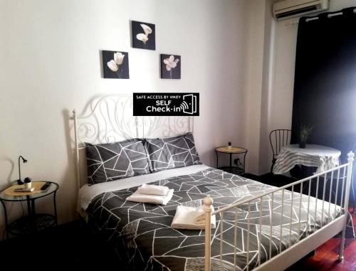 a bedroom with a bed with a black and white comforter at De Rossi Holiday 'Rooms&Apartment' in Bari