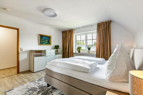 a bedroom with a large bed and a window at Ferienwohnung Meeressand in Sankt Peter-Ording