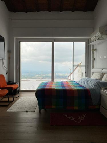 a bedroom with a bed and a large window at San Marino Skyline - Suite Olimpio in San Marino
