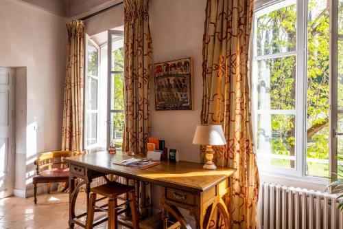 einen Schreibtisch in einem Zimmer mit einem großen Fenster in der Unterkunft Hostellerie De L'abbaye De La Celle - Teritoria in La Celle