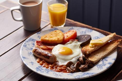 a plate of breakfast food with eggs sausage beans and toast at Fieldhead Hotel by Greene King Inns in Markfield