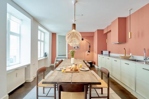 duża kuchnia z drewnianym stołem i krzesłami w obiekcie Stylish Spacious Flat w 3BR in Copenhagen City w Kopenhadze