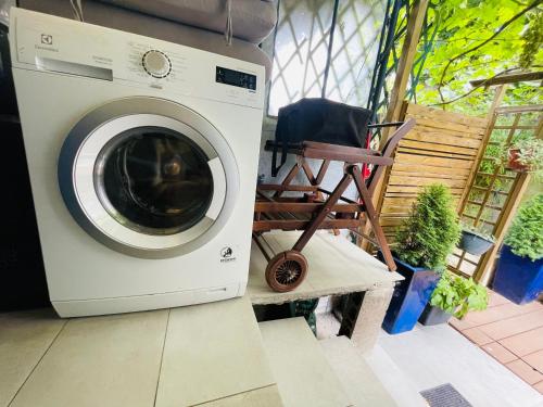 a washing machine sitting next to a chair on a porch at Studio indépendant de 25m2 in Vitry-sur-Seine