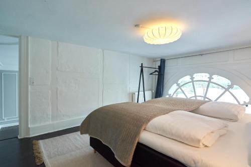 a bedroom with a bed with a light above it at Stylish Spacious Flat w 3BR in Copenhagen City in Copenhagen