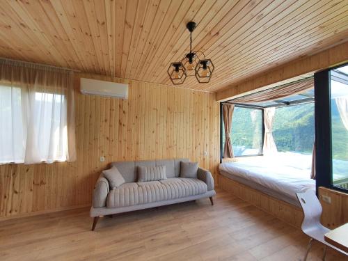 ein Wohnzimmer mit einem Sofa und einem Fenster in der Unterkunft Villa Machakhela●ვილა მაჭახელა in Batumi