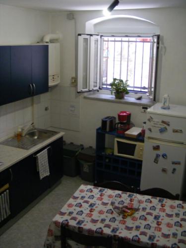 eine kleine Küche mit einem Waschbecken und einem Tisch darin in der Unterkunft Dai Pescatori Nervi in Genua
