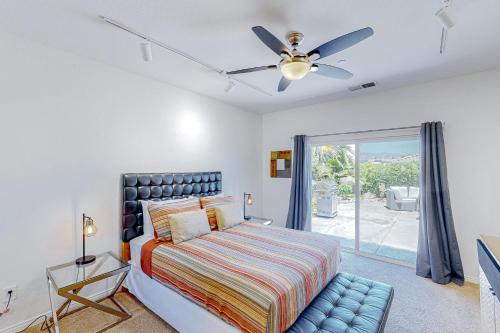 una camera con letto e ventilatore a soffitto di Tranquil Tierra a Palm Springs