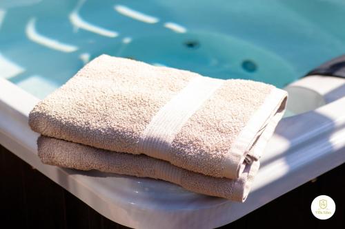 three towels sitting on a table next to a swimming pool at Villa Eden - Design-Sea-Pool-Sauna-Services in Kemionsaari
