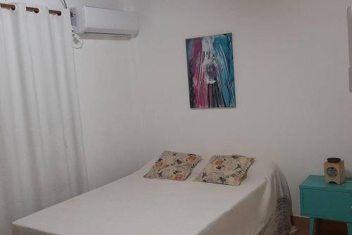 Una cama con dos almohadas encima en una habitación. en Dpto Céntrico dpto 4, en Puerto Iguazú