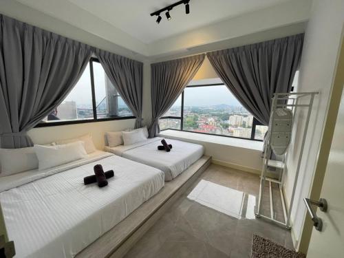 two beds in a room with large windows at Imperio Private Bathtub Melaka Town By MICASA GROUP in Melaka
