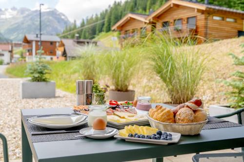 un tavolo da picnic con cibo, pane e latte di Apart-Hotel Laurus Lech a Lech am Arlberg
