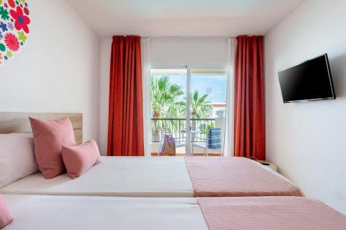 a bedroom with a large bed and a balcony at Hotel Vibra Bossa Flow - Adults only in Playa d'en Bossa