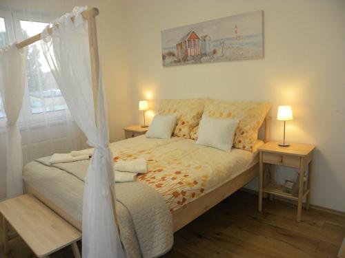 a bedroom with a bed with a canopy at TomJohn Apartman Siófok in Siófok