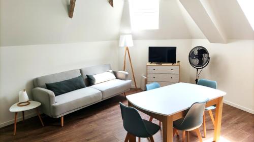 a living room with a couch and a table at Spacieux studio à 7min de Walibi in Les Avenières