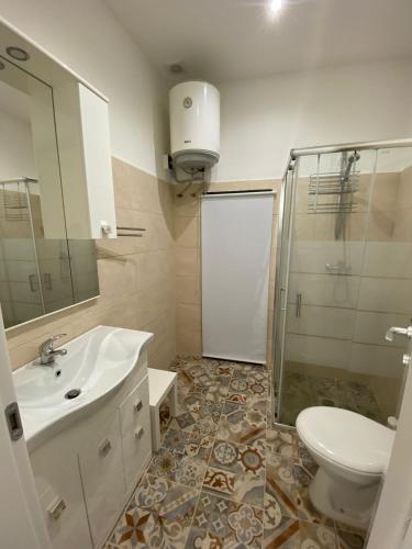ein Bad mit einem Waschbecken, einer Dusche und einem WC in der Unterkunft Salento Sunny Flat in Aradeo