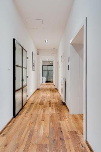 um corredor vazio com paredes brancas e pisos de madeira em Mariacka 13 Wygodne Spanie P6 Centrum em Katowice