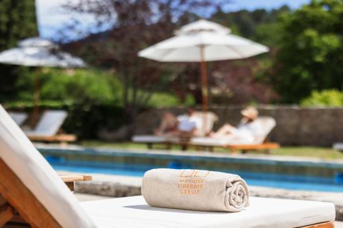 une serviette enroulée posée sur une table à côté d'une piscine dans l'établissement Hostellerie De L'abbaye De La Celle - Teritoria, à La Celle