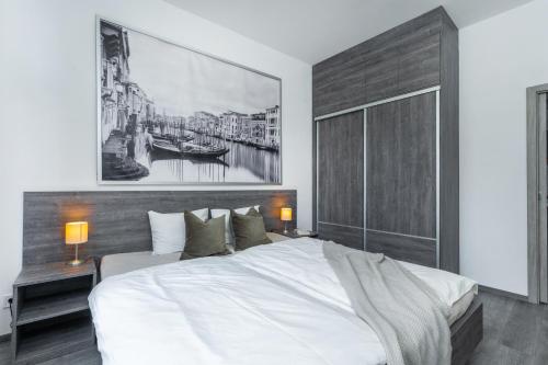 プラハにあるWenceslas square apartmentのベッドルーム(白い大型ベッド1台、絵画付)